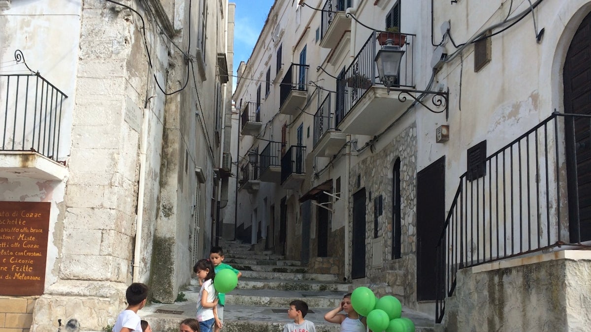 A group of children sitting on the steps of a building